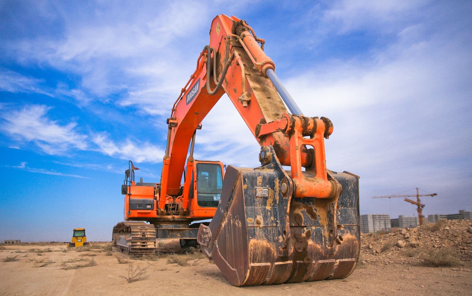 Tracked excavator with bucket ready on a construction site